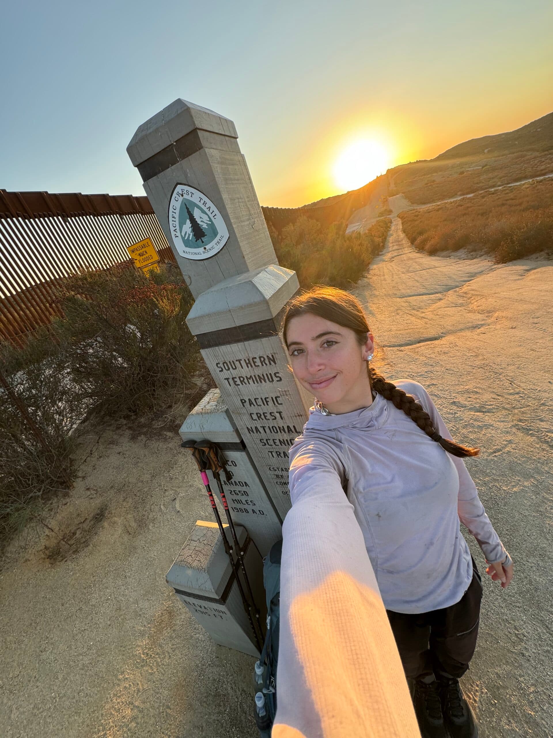 Katie Dominguez at the Pacific Crest Trail Southern Terminus monument at sunrise